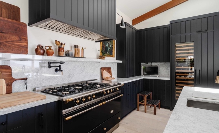 Remodeled kitchen with black appliances and black cabinets